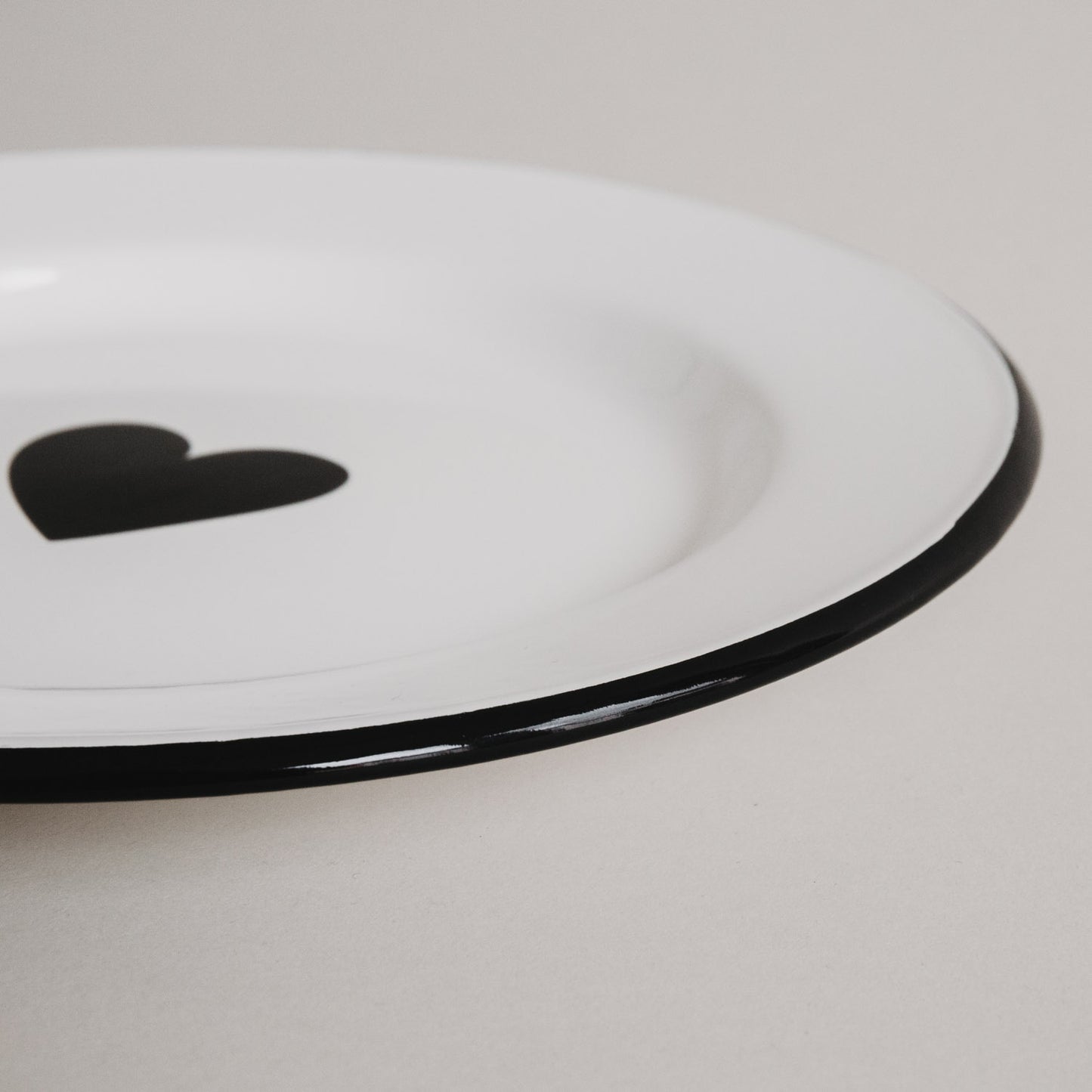 Detailaufnahme des Emaille Speisetellers Herz – schwarzer Rand und glänzende Oberfläche im Fokus.