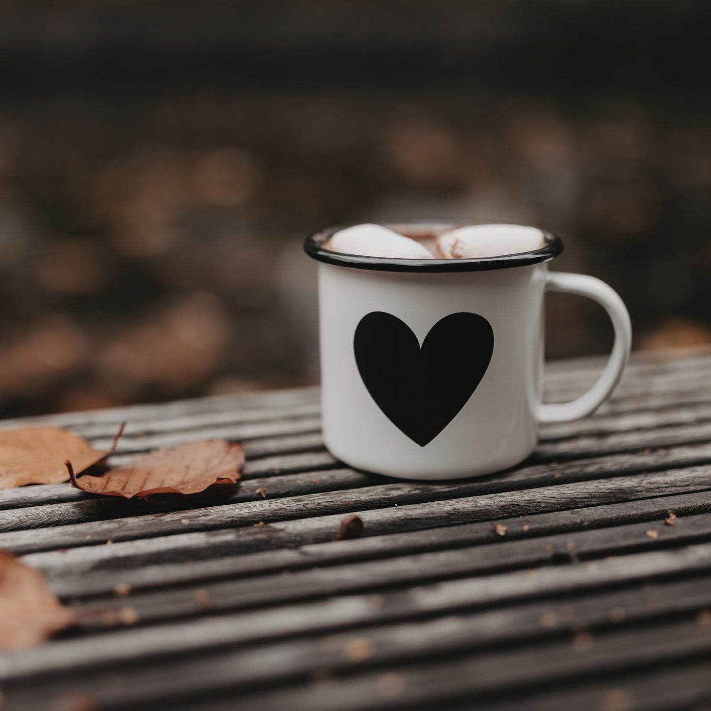 Emaille Tasse Herz mit Marshmallows auf Holztisch – stilvoller Begleiter für heiße Getränke im Herbst.