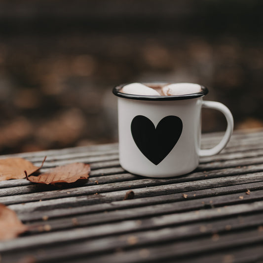 Emaille Tasse Herz mit Marshmallows auf Holztisch – stilvoller Begleiter für heiße Getränke im Herbst.