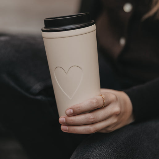 To-go Becher Herz creme mit schwarzem Deckel, stilvoller Begleiter für unterwegs.