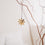 Goldener Metallanhänger Blume am Zweig – minimalistische Osterdeko.