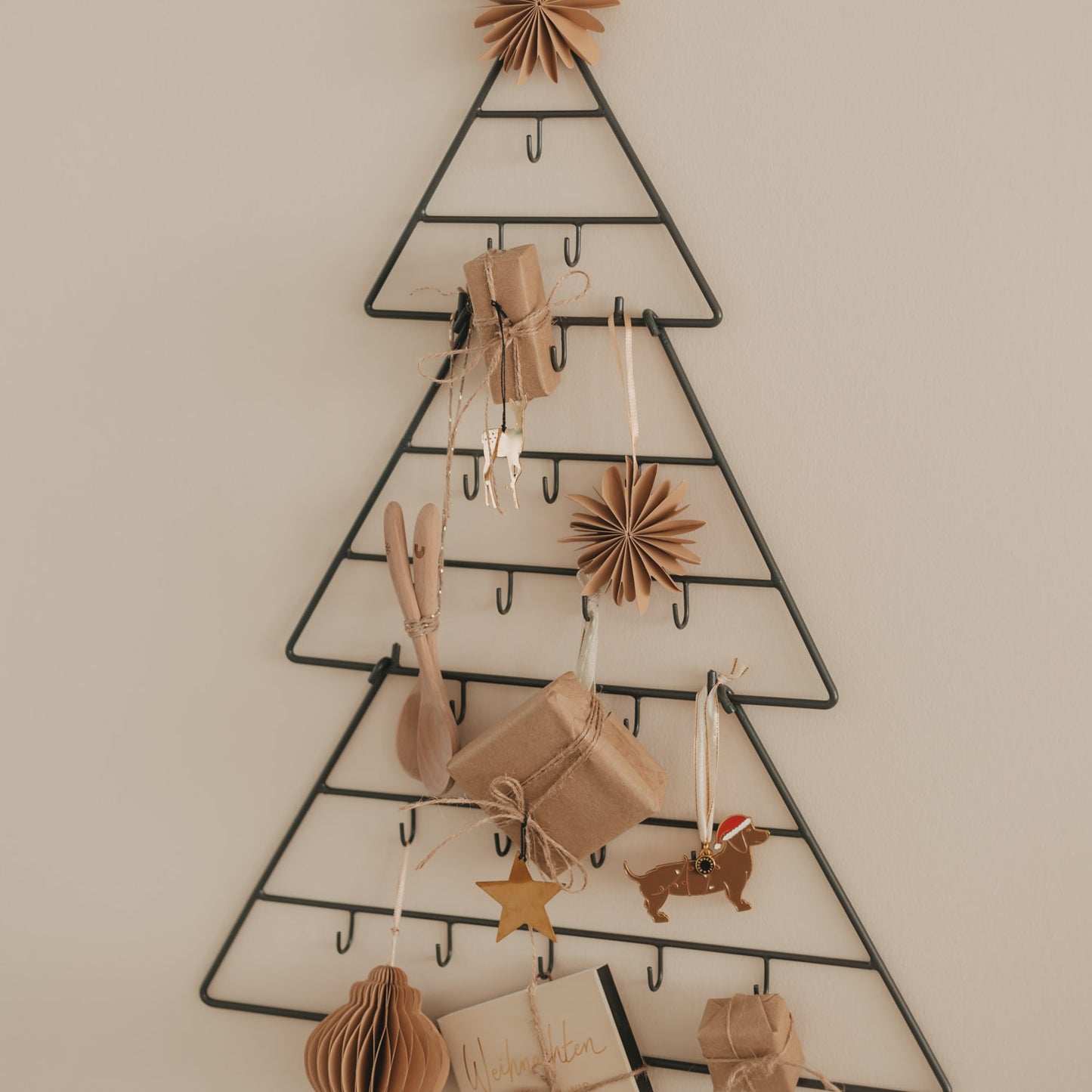 Adventskalender Tanne Metall dekoriert mit Geschenken, Holzlöffeln und weihnachtlichen Anhängern