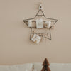 Kleiner Adventskalender Stern aus Metall an der Wand, minimalistisch mit Geschenken und Anhängern dekoriert