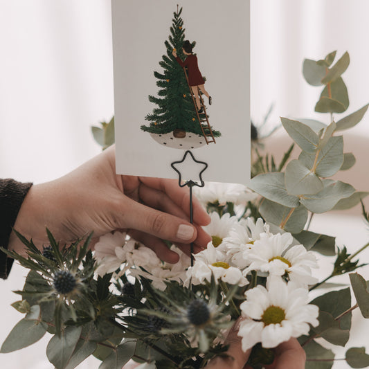 Anthrazitfarbener Stern Metallstecker als Kartenhalter in Blumenstrauß mit weihnachtlicher Grußkarte