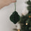 Papieranhänger in Dunkelgrün vor Weihnachtsbaum – festliche Baumdeko mit stilvollem Charakter.
