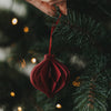 Roter Papieranhänger in Kugelform am Weihnachtsbaum