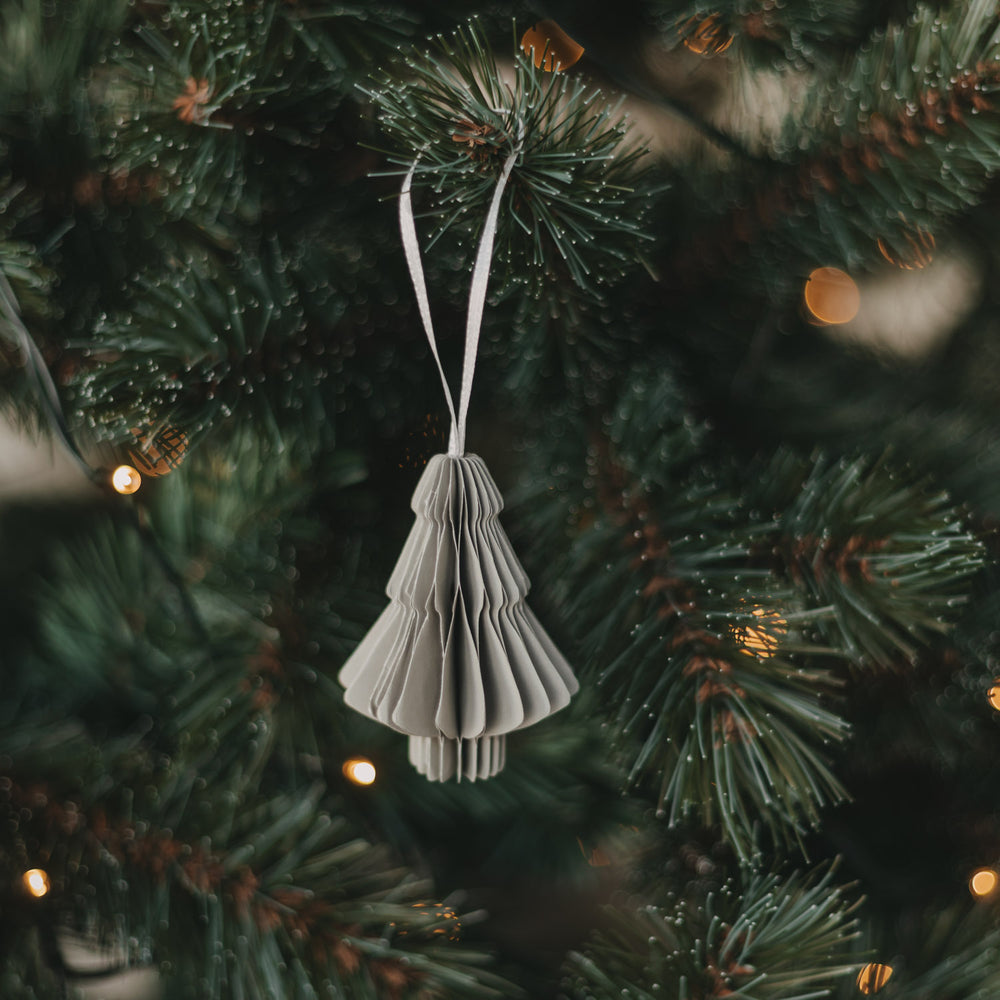 Grauer Papierbaum aus Papier als stilvoller Christbaumschmuck am Tannenzweig