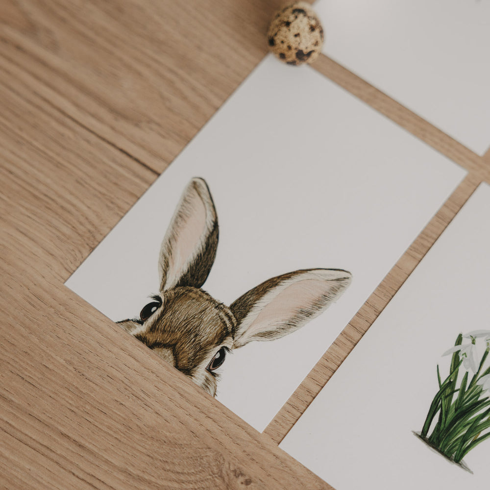 Aquarellkarte mit Hasenmotiv, Nahaufnahme der Karte zwischen Deko-Eiern.