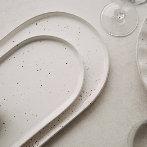 Detailaufnahme der Calma Servierplatten in groß und klein mit elegantem Rand und Sprenkel-Optik