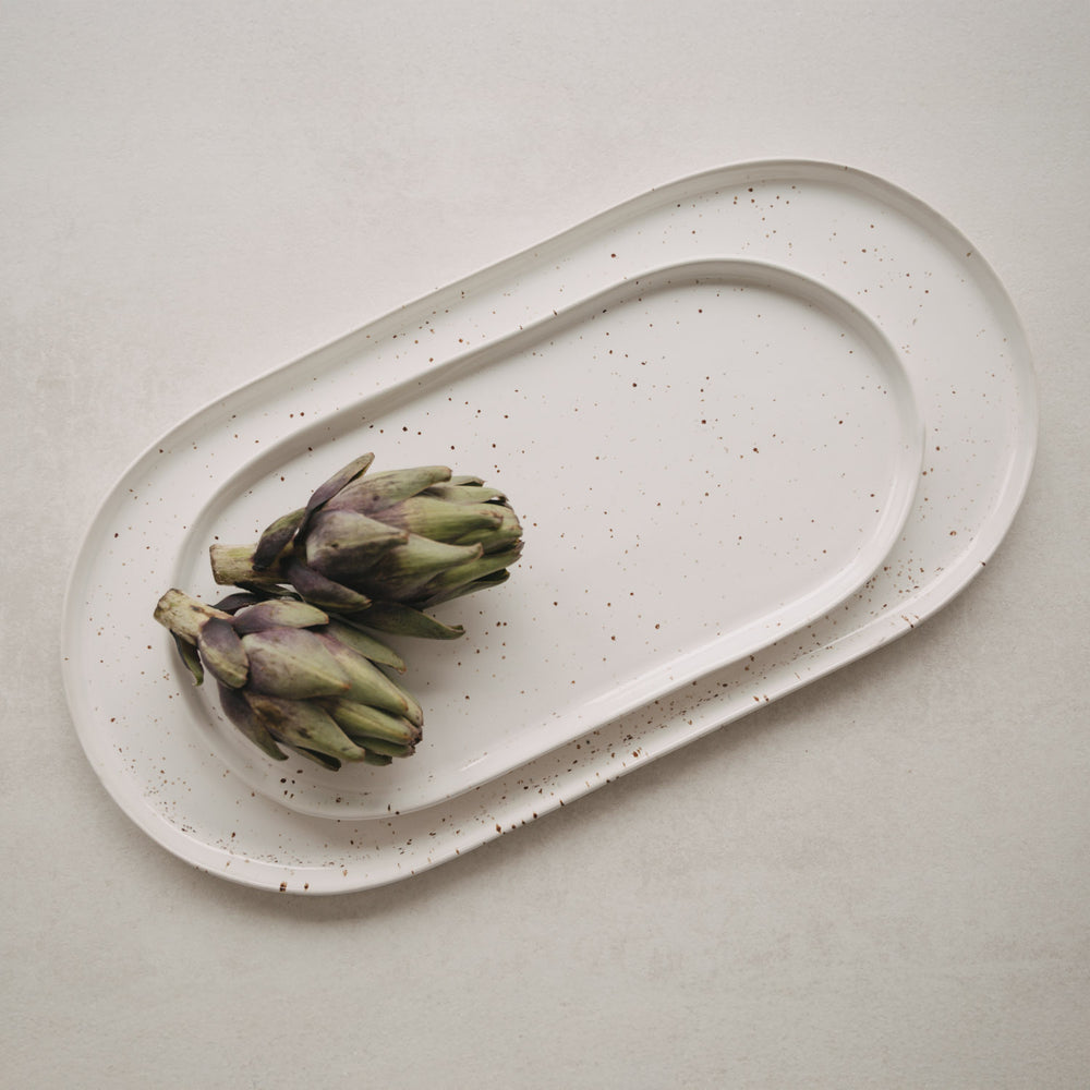 Zwei Artischocken auf der weißen Servierplatte Calma groß mit feinem Sprenkelmuster