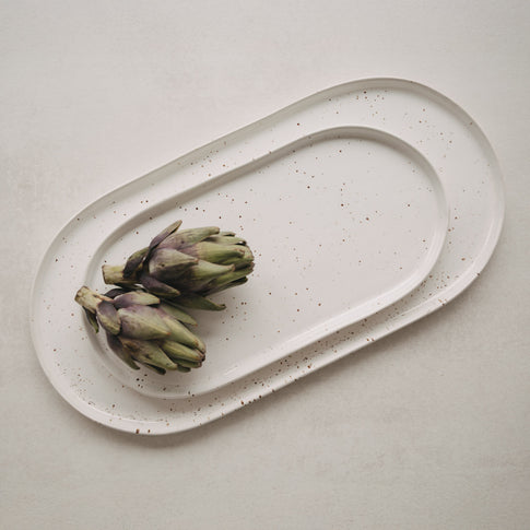 Zwei Artischocken auf der weißen Servierplatte Calma groß mit feinem Sprenkelmuster