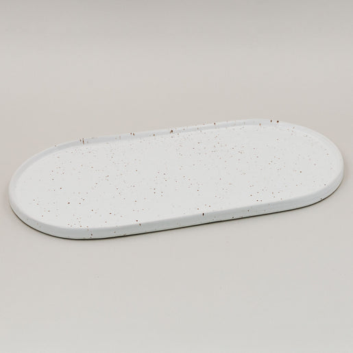 Weiße ovale Servierplatte Calma groß mit Sprenkelmuster auf hellem Hintergrund