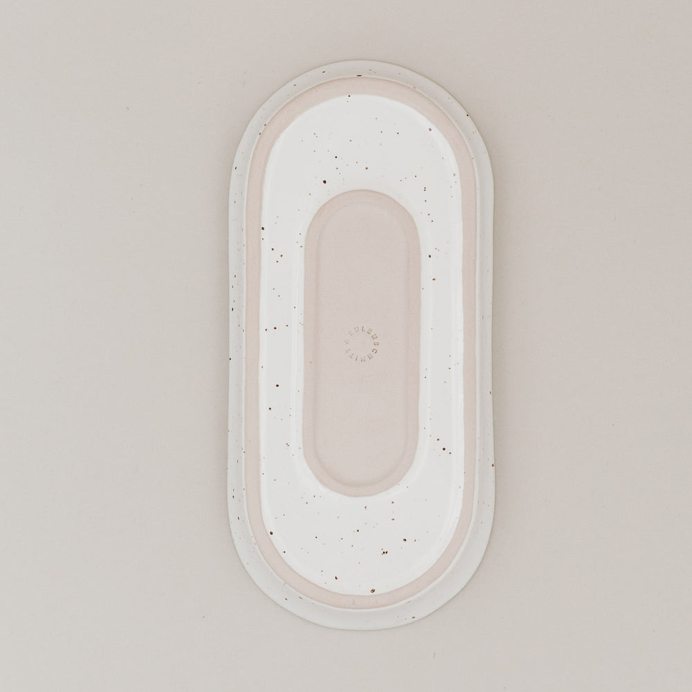 Unterseite der ovalen Servierschale Calma klein aus Steingut mit natürlichem Sprenkelmuster