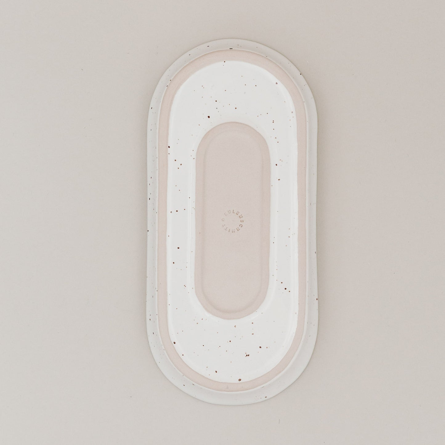 Unterseite der ovalen Servierschale Calma klein aus Steingut mit natürlichem Sprenkelmuster