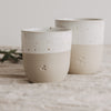 Zwei Keramik Mini Becher mit Herzprägung in Beige Weiß, handgefertigter Look auf Leinentuch