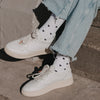 Detailaufnahme weißer Socken mit schwarzem Herzmuster und Sneakern im Alltag