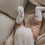 Baby liegt auf Decke, trägt weiße Socken mit Schrift „Kleines Wunder“, gemütliche Szene