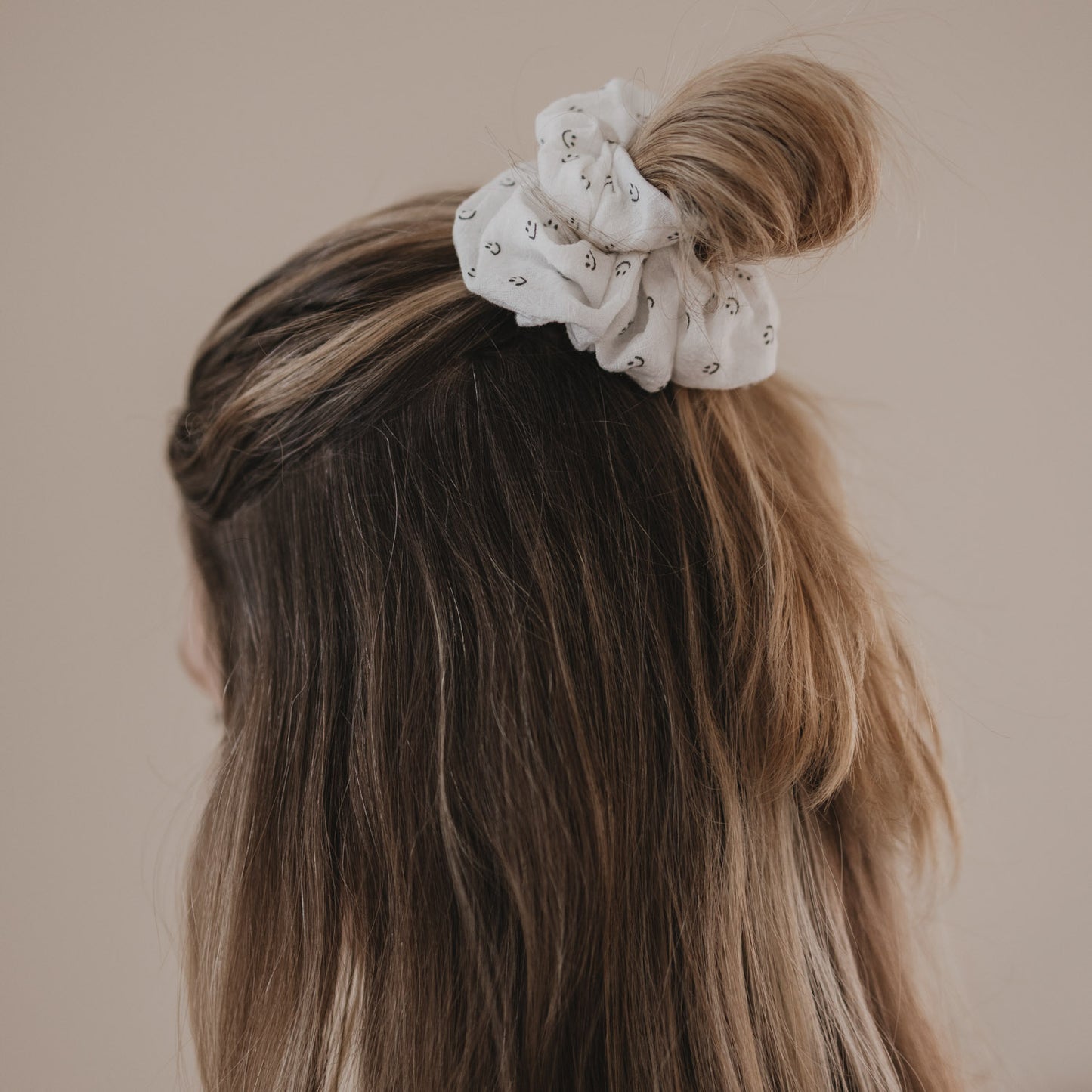 Weißes Scrunchie mit Smiley-Muster hält halboffenen Dutt im Haar