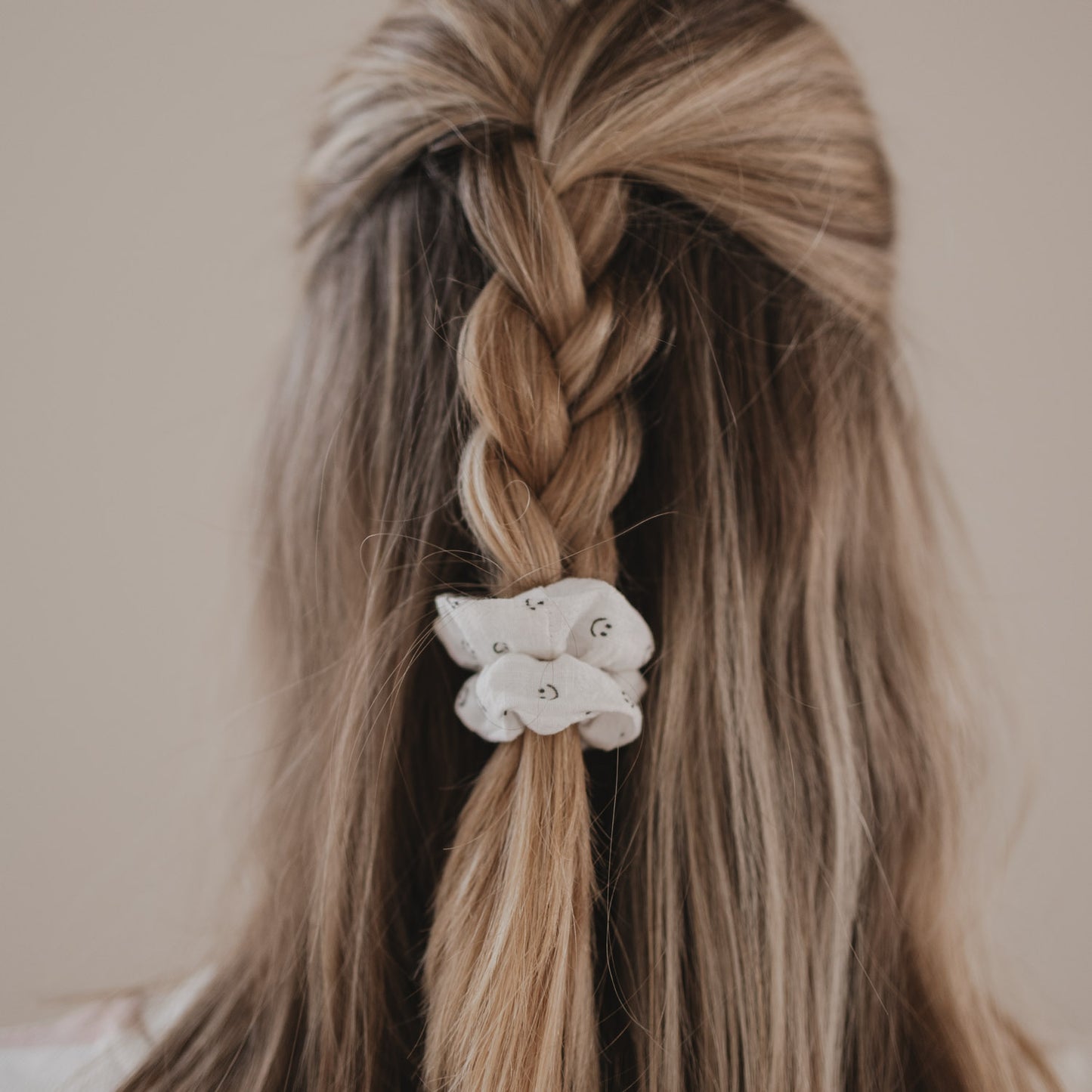 Scrunchie mit Smiley-Muster fixiert geflochtenen Zopf von hinten