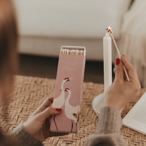 Geöffnete Streichholzschachtel „Kleine Auszeit“ beim Anzünden einer Kerze