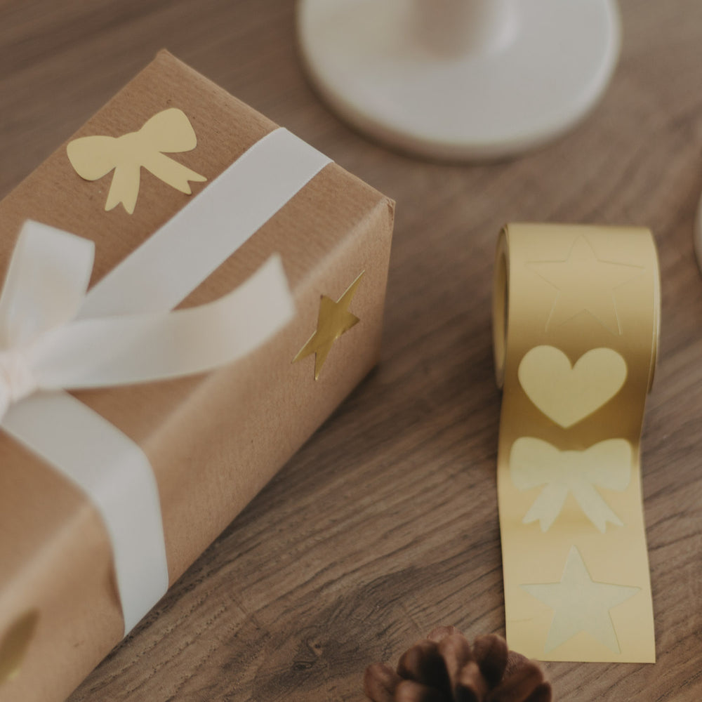 Geschenk mit weißem Band und goldenen Aufklebern Stern und Schleife zur Dekoration