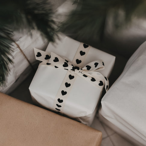 Geschenk mit Baumwollband und schwarzen Herzen verpackt