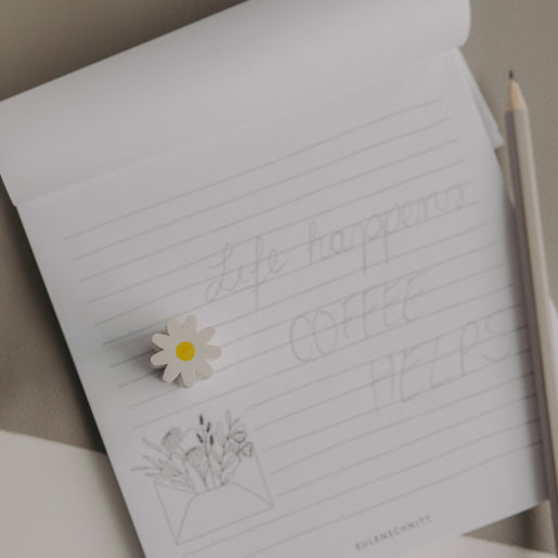 Radiergummi Daisy einzeln auf Notizblock neben Bleistift