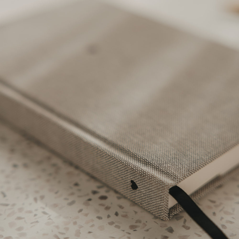 Kariertes A5 Notizbuch mit schwarzem Herz am Buchrücken und schwarzem Leseband