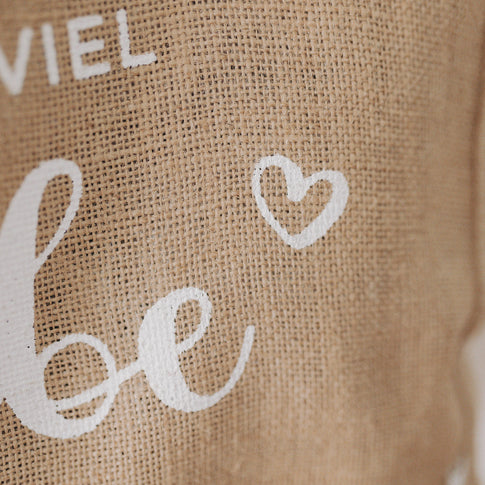 Detailaufnahme der Schrift „viel Liebe“ mit Herzsymbol auf der Jutetasche – Typografie steht im Vordergrund.