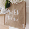 Nahaufnahme der „Markttasche“ mit Blumenfüllung, leicht schräg von der Seite fotografiert – natürliche Materialien im Fokus.
